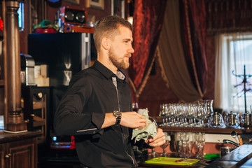 bartender is wiping a glass