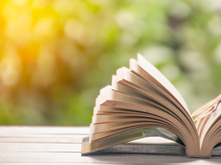 Half open book on table with nature background
