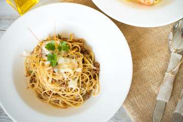 Spaghetti with tomato paste, hot Chili peppers and olive oil. On rustic background. Top view