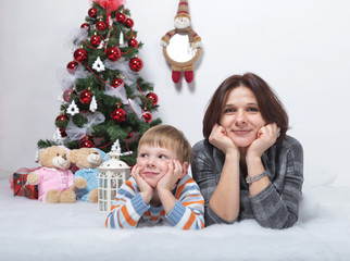 Fototapeta na wymiar mother with her young son on a white background in a Christmas tree