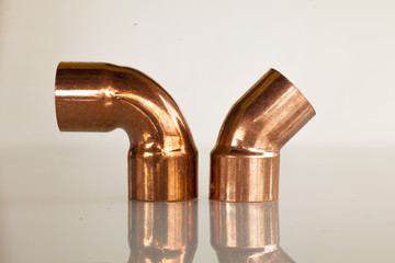 Copper elbow pipe on glass surface