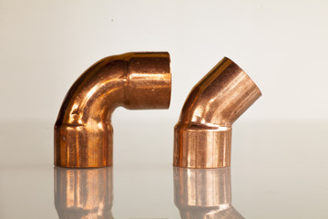 Copper elbow pipe on glass surface
