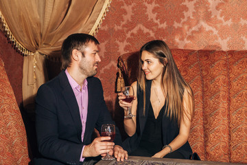 beautiful couple sitting in a fancy restaurant and talking