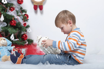 child playing near the Christmas tree on a white background