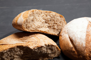 Homemade bread on a black wooden background
