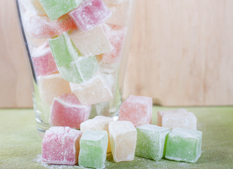 Turkish delight or lokum of red, green and yellow colors in a glass