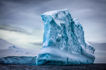 Antarctic iceberg in the snow floating in open ocean. Beauty world