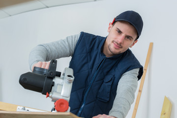 full length portrait of handsome young carpenter indoors