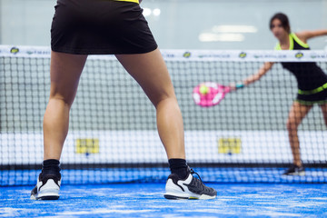 Fototapeta premium Two young women playing paddle tennis.