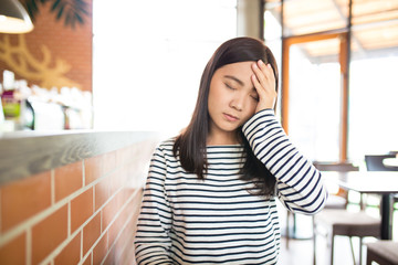 Woman has headache in the cafe