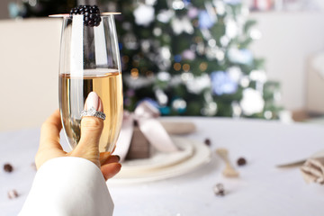 Woman holding glass of champagne making a toast.