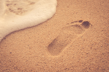 Sand beach foot print with smooth wave. Travel concept.
