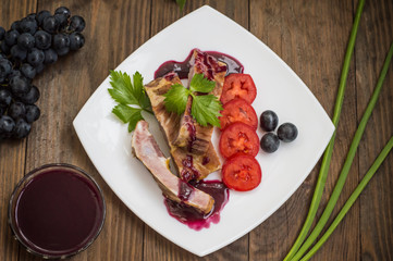 Smoked pork ribs with grape sauce, herbs and vegetables. Wooden background. Top view. Close-up