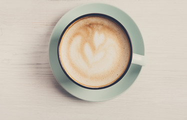 Cappuccino foam, coffee cup top view on white wood background