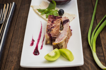 Smoked pork ribs with grape sauce, herbs and vegetables. Wooden background. Top view. Close-up