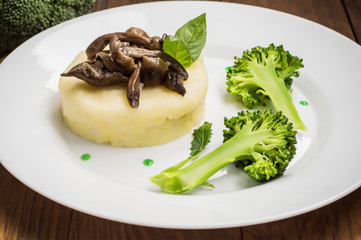 Mashed potatoes with mushrooms and boiled broccoli  sauce. Wooden background. Top view. Close-up