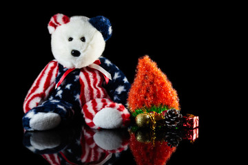 American teddy bear with ornaments on a festive Christmas tree.