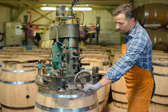 Cooper using machine to make barrel