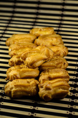 Rows of eclairs on a bamboo mat. Selective focus