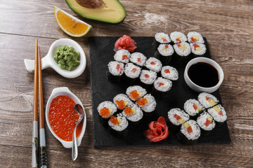 sushi rolls and ingredients served on a wooden surface