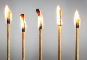 Many burning matches stand in a row