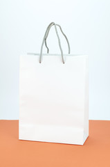 Blank paper white bag on orange and white background.