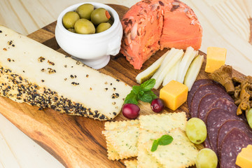 Starter plate with sliced salami and assorted cheese.