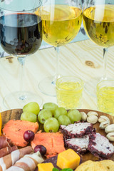 Starter plate with assorted cheese and meat and variety of alcohol drinks