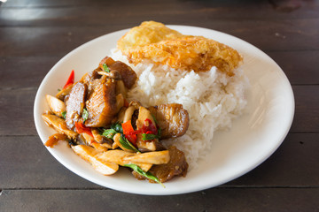 Pork fried rice with basil on wood table