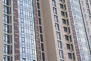 Fototapeta premium Facade of a modern high-rise building. Construction and architec