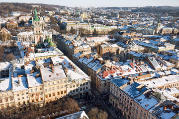 Fototapeta premium Winter panorama view from the Town Hall on the downtown in Lviv, Ukraine. Old buildings. Roofs covered with snow.