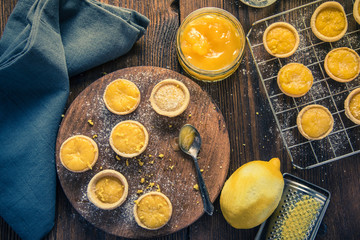 filling lemon and custard mini tarts on wooden board