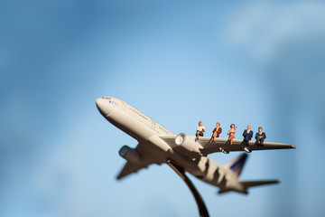Miniature people on airplane using as background travel or busin