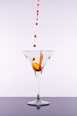 Red Cocktail Splashing From Martini Glass Isolated on White Background. Bar Commercials Concept.