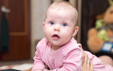 Fototapeta premium Baby with blue eyes looking at the camera