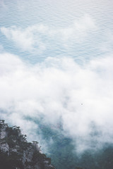 Fototapeta na wymiar Clouds Foggy Mountains cliff and sea Landscape minimalistic style Travel serene scenic aerial view moody weather