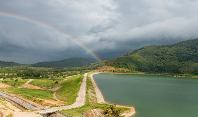 rainbow on dam and mountain background