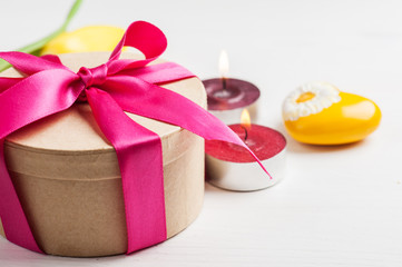 Lit candles and gift box with red ribbon