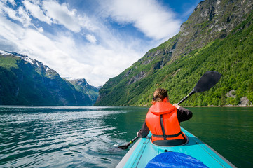 Woman kayaker at Geirngerfjord, Norway.