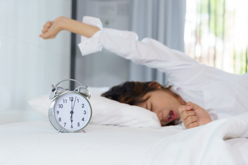 Woman stretching and yawning while waking up in the morning