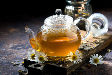 fragrant chamomile tea in a glass teapot