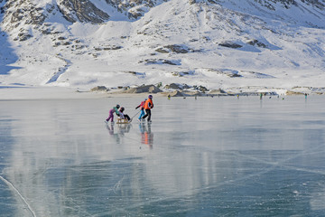 Zugefrorener Lago Bianco auf der Berninapasshöhe, mit Personen, Graubünden, Schweiz