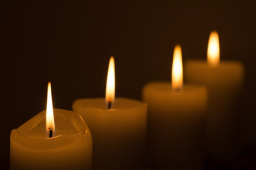 Fototapeta na wymiar four candles in the dark