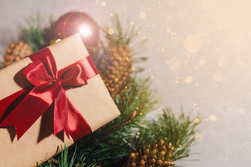 New Year's gift, toy, card, cones. New Year composition on gray concrete background. Snowflakes in the foreground. Warm light in the corner.