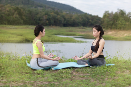 Beautiful Young Girls Practicing Yoga River Side