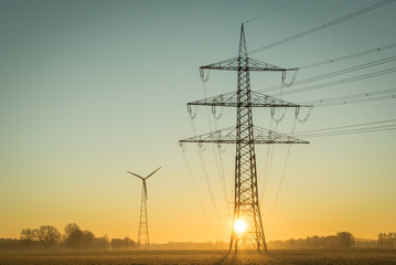 Netzausbau - Erneuerbare Energien, Strommast vor aufgehender Sonne