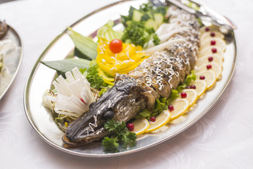 Stuffed pike decorated with vegetables and the greens. Very beautiful restaurant dish