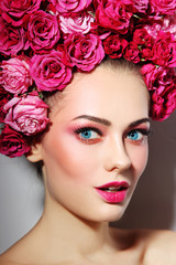 Naklejka premium Young beautiful happy woman with fresh make-up in wig of roses