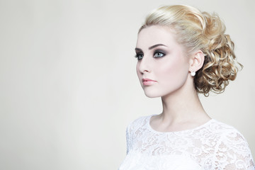 Young beautiful blonde bride with stylish prom hairdo and make-up © Olga Ekaterincheva