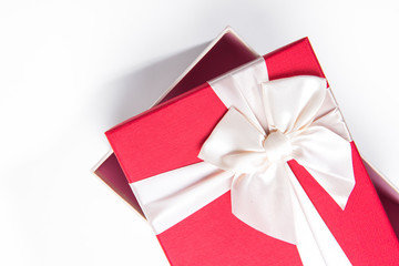 Red gift box with white ribbon isolated on white background. 